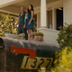 A screenshot from the Fast and Furious film showing two characters stood outside a house.